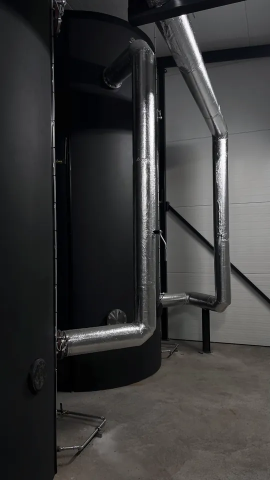 Black accumulator tanks with insulated pipes.