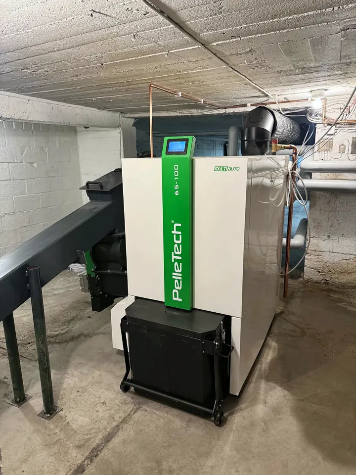The PelleTech Multiauto 100 in the basement boiler room, with the ash box on wheels.
